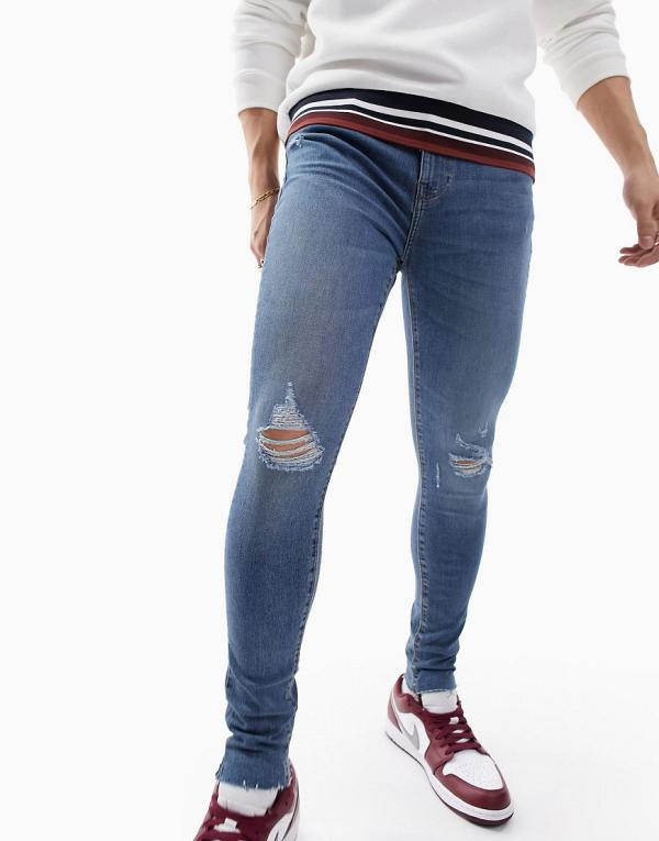 ASOS DESIGN spray on jeans with power stretch in mid wash blue with abrasions