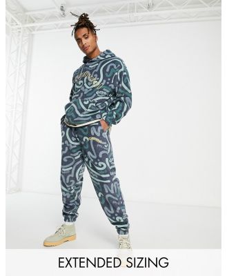 ASOS Daysocial relaxed trackies in polar fleece with all over doodle print in navy (part of a set)