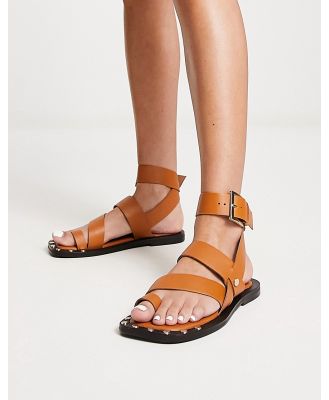 ASOS DESIGN Foxy leather studded toe loop flat sandals in tan-Brown
