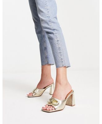 ASOS DESIGN Hush snaffle detail mid heeled mules in gold