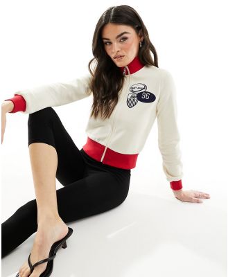ASOS DESIGN zip up sweatshirt with sports graphics in cream-White