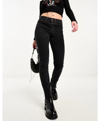 COLLUSION x001 mid rise drainpipe skinny jeans in washed black with raw hem