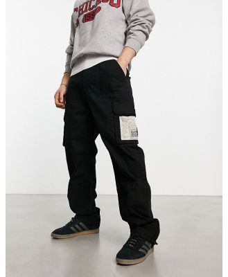 Karl Kani signature cargo pants in black with woven patch