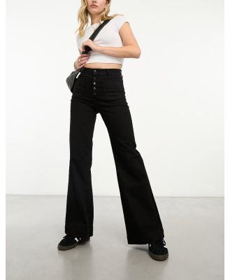 & Other Stories high waist flared leg jeans with button front detail and patch pockets in black