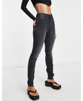 River Island high rise skinny jeans with split zip hem in washed black